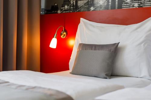布尔诺维史塔酒店的一张带白色枕头和红色墙壁的床