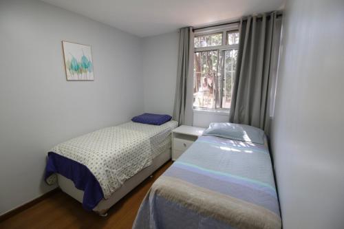 巴西利亚Apartamento ASA SUL的一间卧室设有两张靠窗的床。