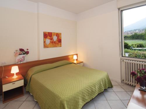 科利科Green Village Accommodations的一间卧室设有一张绿色的床和一个大窗户