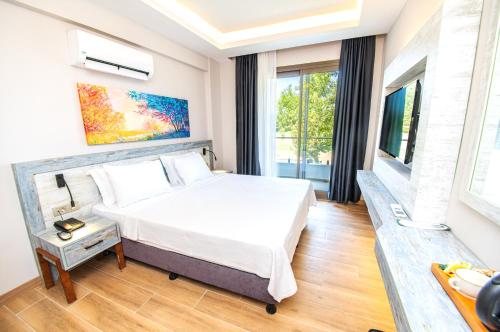 达特恰Feri Surf Club Hotel Datça的一间卧室设有一张床和一个大窗户