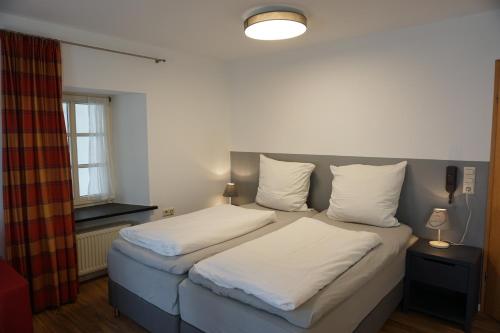 贝尔恩卡斯特尔-库斯Feriengut Bohn的一间卧室设有两张带白色床单的床和窗户。