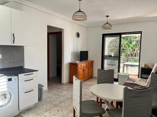 卡布罗伊格Apartment with Outdoor Pool and Air Conditioning in Cabo Roig的厨房以及带桌子和桌椅的用餐室。
