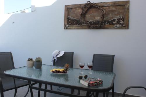 梅萨雷亚THE ROCK LUXURY HOMES的一张桌子,上面放着一碗水果和两杯葡萄酒