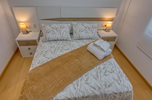 菲尼斯特雷O Aserradero的一间卧室配有一张带2个床头柜的大床