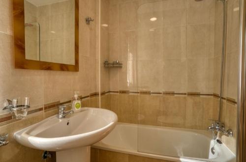 菲尼斯特雷O Aserradero的浴室配有盥洗盆和浴缸。