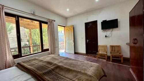 列城Nordan guest house Ladakhi room的一间卧室配有一张床和一台平面电视