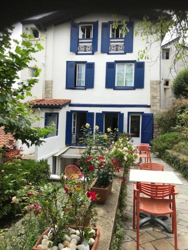 圣让-德吕兹Hôtel Ohartzia的蓝色和白色的房子,前面有鲜花