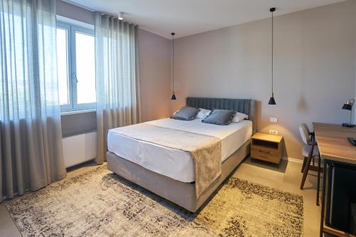 伊佐拉Dolcemente Garni Hotel Superior的一间卧室配有一张床、一张书桌和一个窗户。