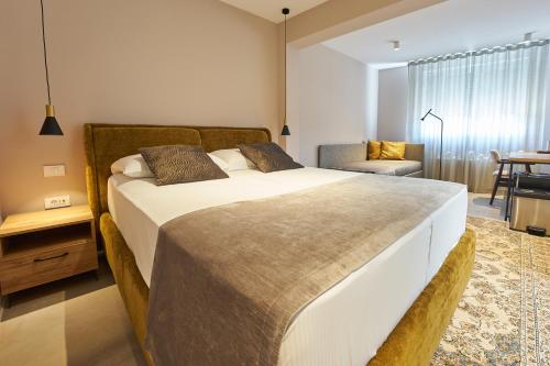 伊佐拉Dolcemente Garni Hotel Superior的一间卧室配有一张大床和一把椅子