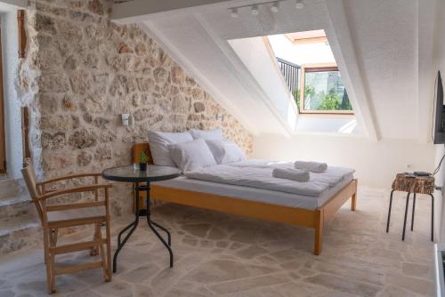 特雷比涅Hotel Restoran Humsko的一间卧室配有一张床、一张桌子和一个窗户。