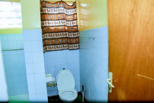 基加利INZOZI AFRICA HOUSE B&B-Kimihurura的浴室设有卫生间和窗帘