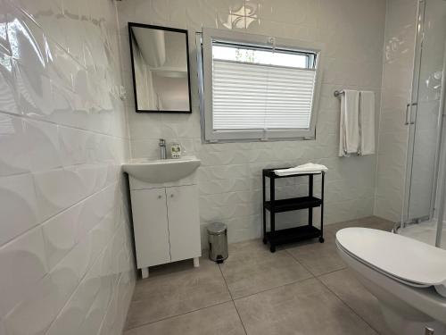 Sun House的白色的浴室设有水槽和卫生间。