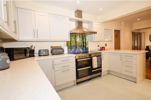 FewstonBramall House Accommodation的厨房配有白色橱柜和炉灶烤箱。