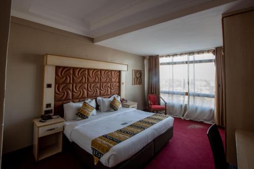 ThikaThe Luke Hotel Cravers Thika的一间设有大床和窗户的酒店客房