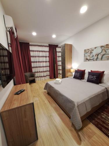 马尔萨斯卡拉B&S Accommodation Seafront Duplex Penthouse的一间卧室配有大床和红色窗帘