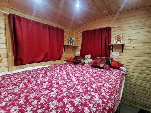Villeneuve-de-RivièreLa Roulotte du Cagire - 4 pers - Pyrénées的一间卧室配有一张带红色毯子的大床