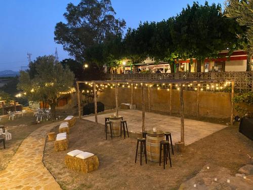 卡斯特尔比斯堡L'Olivera Casa Rural的庭院配有桌椅和灯