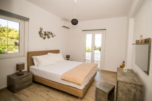 安倍拉斯Villa Zou的白色的卧室设有床和窗户