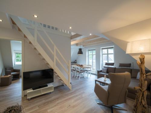 斯匹科罗格Inselsünn Spiekeroog的带沙发和电视的客厅以及楼梯。