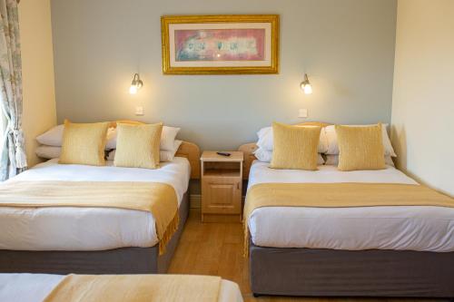 恩尼斯克朗Ceol na Mara Guest House的酒店客房设有两张床和一张桌子。