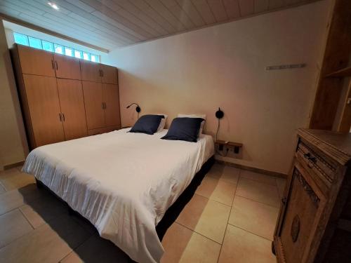 洛布Gîte de l'Entreville的卧室配有带蓝色枕头的大型白色床