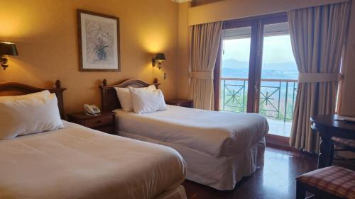 富特罗诺Hotel y Cabañas Lago Ranco - Caja los Andes的酒店客房设有两张床和一个阳台。