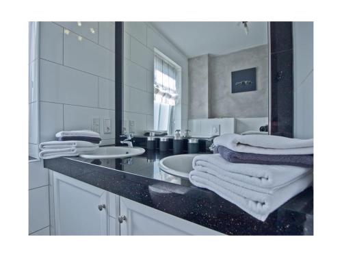 诺德奈Strandbox & Strandresidenz的白色的浴室设有两个盥洗盆和镜子