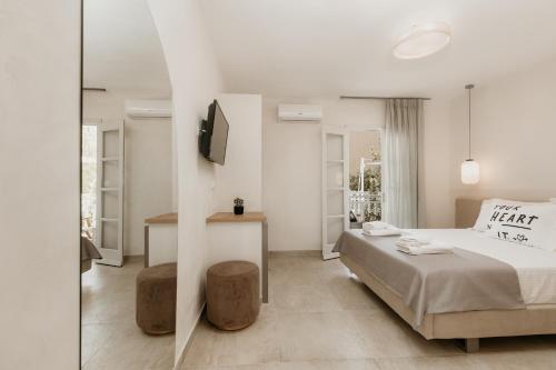 阿莫利亚尼岛TRINITY THE HOTEL的一间白色卧室,配有床和电视