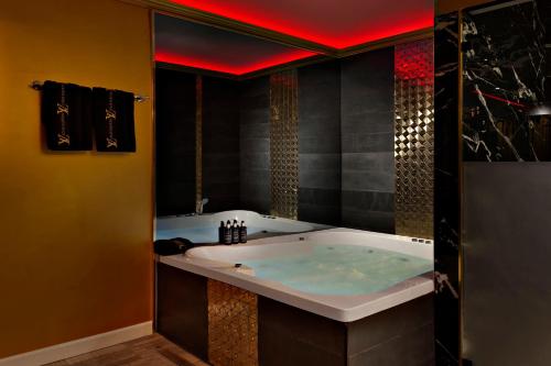 Tel BinyaminMetro Elegance Suites的一间设有红色天花板和浴缸的浴室