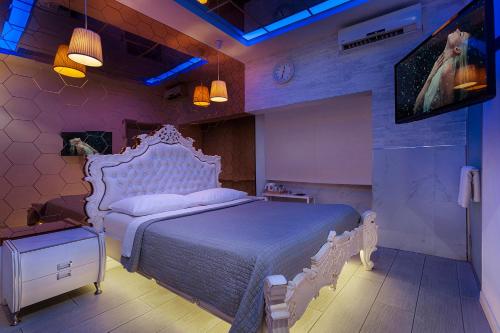 Tel BinyaminMetro Elegance Suites的卧室配有白色的床和电视