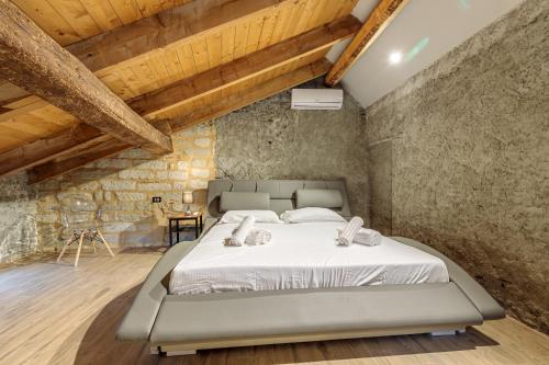 Ozzano MonferratoCascina Liebe con Idromassaggio的卧室配有一张石墙内的大床