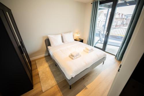 鹿特丹Cool 3 Bedroom Serviced Apartment 68m2的一间卧室配有一张床,上面有两条毛巾