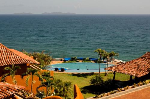 ParaguachiCala Margarita Hotel的享有毗邻大海的游泳池的景致