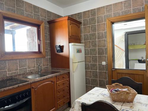 普拉亚布兰卡Villa Burgao的厨房配有水槽和冰箱