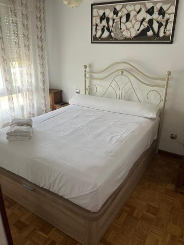 卡马乔Coqueto apto en Maliaño的卧室配有白色床单和白色床。