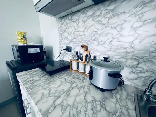 Lo-ocSaekyung Condotel Near Airport的厨房配有白色大理石墙和水槽