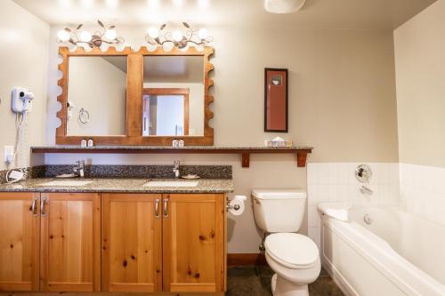 惠斯勒传奇酒店的一间带卫生间、水槽和镜子的浴室