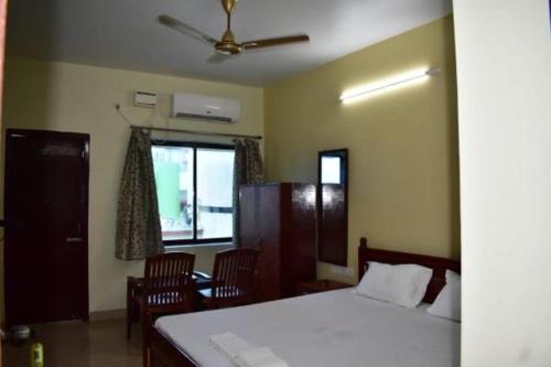 普里Hotel Lovely Palace ! Puri的一间卧室配有床、椅子和窗户