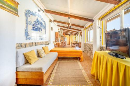 Eclectic oasis with poolside charm in Arranhó的带沙发和电视的客厅