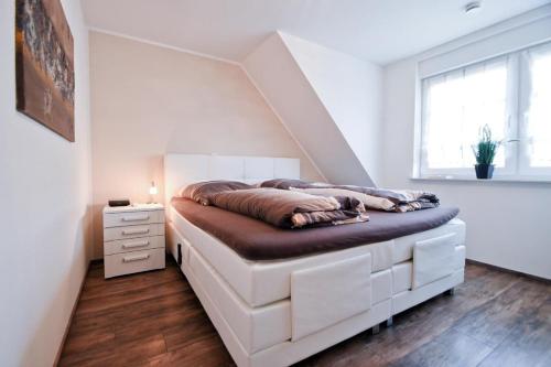 诺德奈Strandbox & Strandresidenz的一间带床的卧室,位于带楼梯的房间