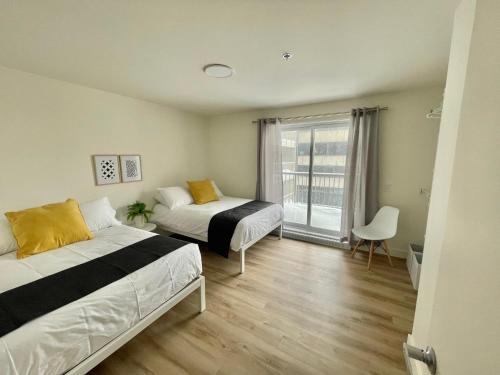 魁北克市APPART-HOTEL L'UNI的一间卧室设有两张床和窗户。