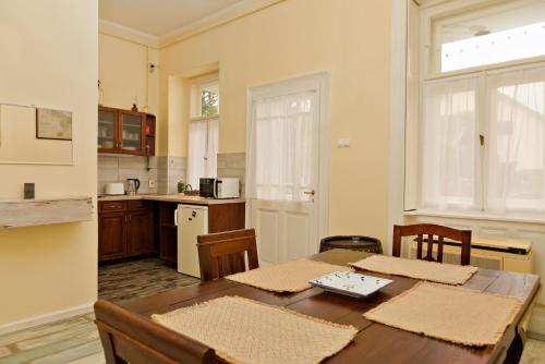 沙罗什保陶克Kurucz Apartman的带桌椅的厨房、带桌子的厨房和厨房。