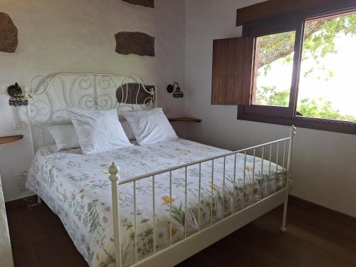 摩亚CASA RURAL CON PISCINA PRIVADA El ROBLE的卧室配有白色的床和窗户。