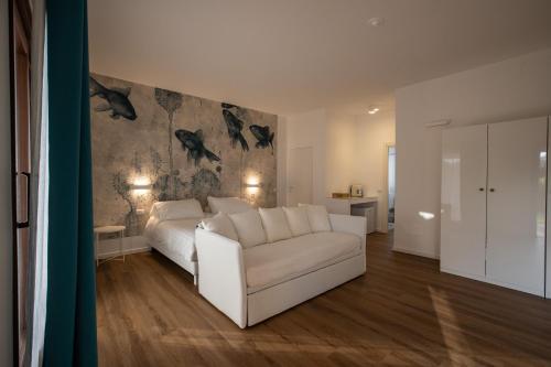 波尔图圣保罗Il Borgo Boutique Rooms by KasaVacanze的一间带白色沙发的客厅和一间卧室