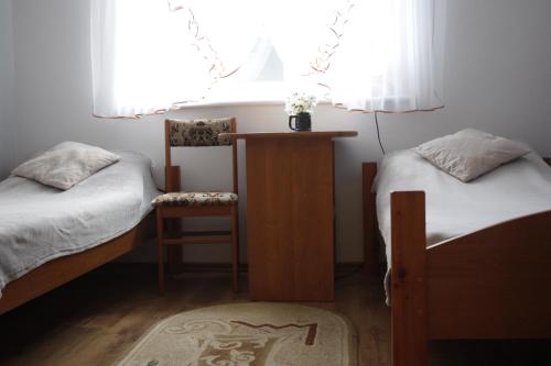 奥斯特罗沃Ugeni ,apartament的一间卧室设有两张床、一把椅子和一个窗户。