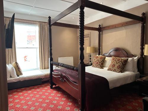 布里奇沃特The Tudor Hotel的一间卧室设有四柱床和窗户。