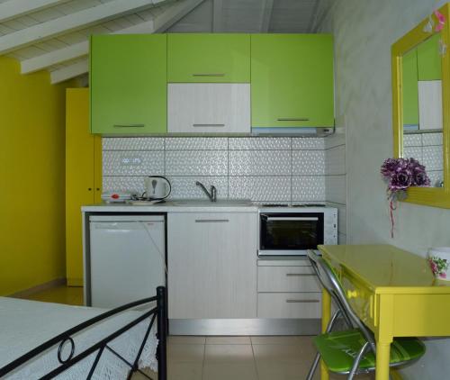 阿洛尼索斯古镇Studios Soula的厨房配有绿色橱柜和黄色桌子