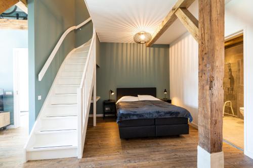 WijheBoerderijkamer 't Keukentje的一间卧室设有楼梯,卧室内设有一张床