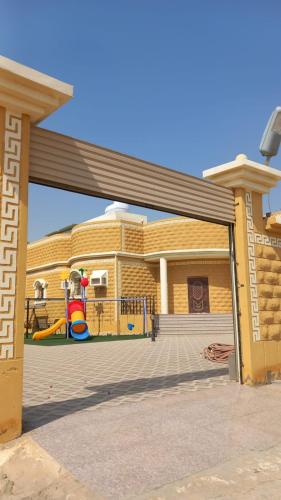 延布شاليه سحاب的一座黄色的建筑,前面有一个游乐场
