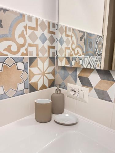 那不勒斯City Home 77的浴室的墙壁上设有瓷砖和水槽。